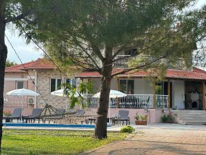 a house with a tree and a swimming pool at Aysel Villa in Ortaca
