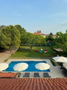 a swimming pool with umbrellas on a roof at Aysel Villa in Ortaca