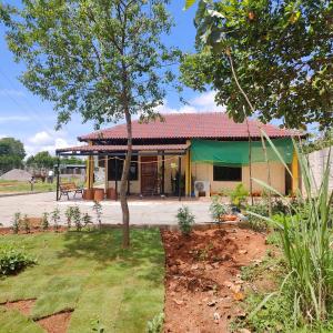 een huis met een boom ervoor bij Encanto Farmstay in Mysore