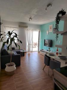 ein Wohnzimmer mit einem Sofa und einer Topfpflanze in der Unterkunft Apartment Čiovo Radić in Trogir
