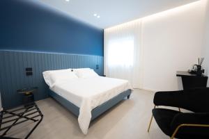 a blue and white bedroom with a bed and a chair at BMC Home in Boscotrecase