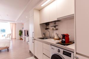 a kitchen with a sink and a washing machine at The castle ocean suite in Yeosu