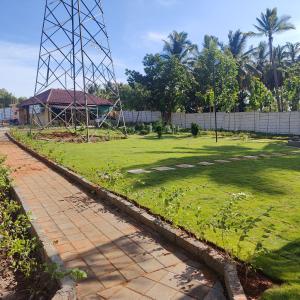 un parque con un campo de césped y una valla en Encanto Farmstay en Mysore