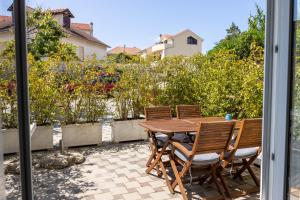 eine Terrasse mit einem Holztisch und Stühlen in der Unterkunft Apartments & rooms Stella Adriatica in Murter