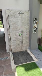 a shower with a hose attached to a brick wall at Dany house 1 in Keramoti