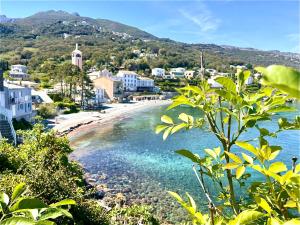 a view of a beach with houses and a town at Tour XIIIe siècle, vue mer, Cap Corse in Brando
