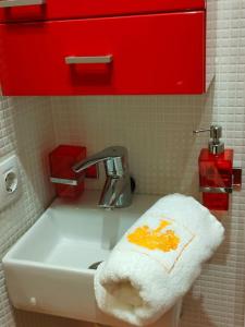 un fregadero blanco con una toalla naranja. en Luminoso apartamento en Grado, cerca de Oviedo, en Grado