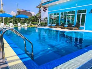 a large swimming pool with chairs and umbrellas at MS Hotel Sriracha in Si Racha