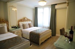 イスタンブールにあるベスト タウン ホテルのベッド2台と窓が備わるホテルルームです。