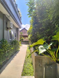 einen Gang neben einem Gebäude mit Pflanzen in der Unterkunft The Island Bali in Seminyak