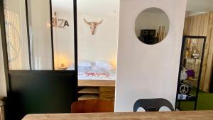 a dining room with a mirror and a table at La MaisonneTTe d'ElodibiZa ! in Moret-sur-Loing