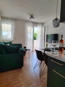 ein Wohnzimmer mit einem grünen Sofa und einem Tisch in der Unterkunft Apartment Čiovo Radić in Trogir