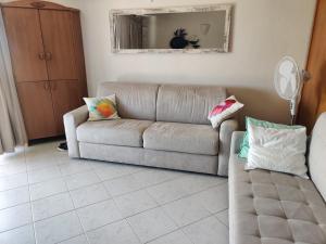 a living room with a couch and a mirror at bilocale vista porto in Cannigione