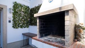an outdoor brick oven with a plant on the wall at Estudio Delfín Azul Playa Ezaro in Dumbría
