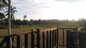 a wooden fence with a view of a field at Eco Hostel Bujak Permai Lombok in Mantang