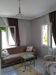 uma sala de estar com um sofá e duas janelas em Beldibi apartment / house / hotel em Antalya