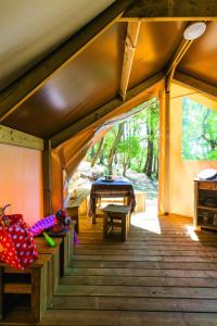 een kamer met een houten veranda met een tafel bij Wellness Sport Camping - La Dune Bleue in Carcans