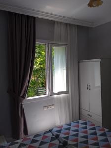 um quarto com uma cama e uma grande janela em Beldibi apartment / house / hotel em Antalya