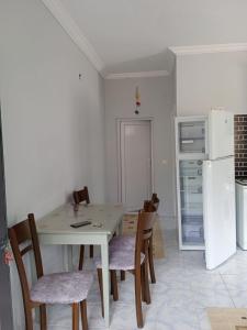 uma cozinha com uma mesa e cadeiras e um frigorífico em Beldibi apartment / house / hotel em Antalya