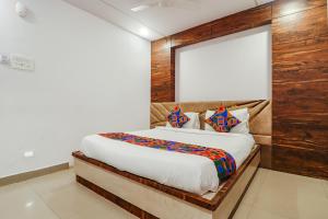 een slaapkamer met een bed met een houten muur bij FabHotel Double Tree in Hyderabad