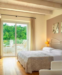 1 dormitorio con 1 cama y puerta corredera de cristal en Hotel Giardino Suites&Spa en Numana