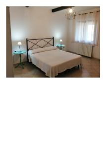 La SdrisciaにあるAgriturismo Oasisのベッドルーム1室(ベッド1台、テーブル2台付)