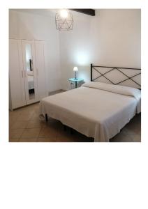 La SdrisciaにあるAgriturismo Oasisのベッドルーム(大きな白いベッド1台、テーブル付)