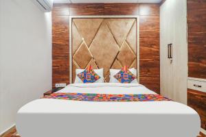 a bedroom with a large white bed with wooden walls at FabHotel Double Tree in Hyderabad