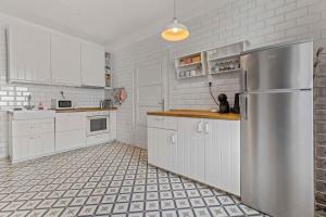 uma cozinha com armários brancos e um frigorífico de aço inoxidável em AH Legionárska em Bratislava