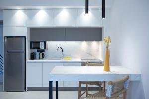 cocina con mesa blanca y nevera en Achillion Suites, en Lefkada