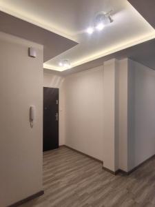 an empty room with white walls and a black door at Apartament Słowińców 61 in Wejherowo