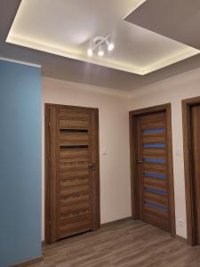 a room with two wooden doors and a ceiling at Apartament Słowińców 61 in Wejherowo +9 photos
