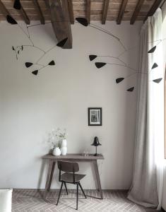 a dining room with a table and a branch on the wall at Pieve Aldina Relais & Châteaux in Radda in Chianti