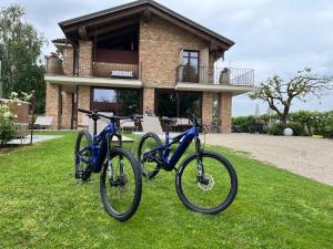 dos bicicletas estacionadas en el césped frente a una casa en Villa Laura, en Castellinaldo