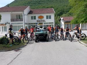 a group of people on bikes in front of a motel at Motel and Restaurant Odušak in Drežnjak