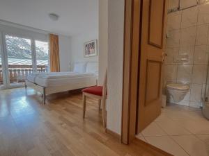 ein Schlafzimmer mit einem Bett, einem WC und einem Fenster in der Unterkunft Residence Chateau in Saas-Fee