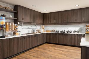 a large kitchen with wooden cabinets and wooden floors at Residence Inn Rochester Mayo Clinic Area South in Rochester