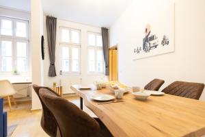 uma sala de jantar com uma mesa de madeira e cadeiras em Ko-Living Space an der Oper - Street Art Design Apartments em Halle an der Saale