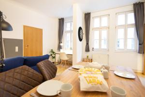 a living room with a blue couch and a wooden table at Ko-Living Space an der Oper - Street Art Design Apartments in Halle an der Saale