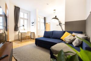un soggiorno con divano blu e tavolo di Ko-Living Space an der Oper - Street Art Design Apartments a Halle an der Saale