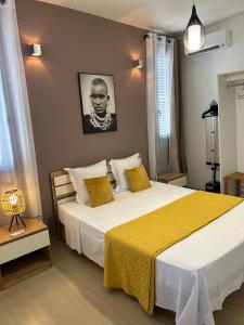 1 dormitorio con 1 cama grande con manta amarilla en Charmant appartement avec terrasse, vue sur lagon en Mamoudzou