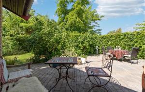 un patio con tavolo, sedie e alberi di 3 Bedroom Nice Home In Risskov a Risskov