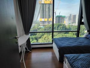 Cette chambre comprend deux lits et une grande fenêtre. dans l'établissement opus residences by sunflower, à Kuala Lumpur