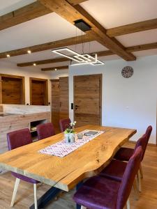 une salle à manger avec une table en bois et des chaises violettes dans l'établissement Apartment Talblick, à Sankt Michael im Lungau