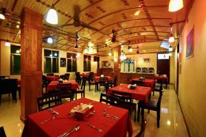 Captal Island Villa في ماثيفيري: مطعم بطاولات حمراء وكراسي في الغرفة