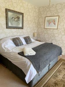 una camera da letto con un grande letto con lenzuola e cuscini bianchi di Stone House a Kington