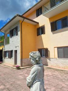 Una statua di una ragazza davanti a un edificio di La casa di mezzo-affitti brevi-zona ospedali a Busso
