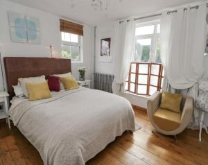 - une chambre avec un lit, une chaise et des fenêtres dans l'établissement Lovely Comfortable 3 Bed Home, Worcester, à Worcester