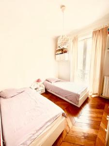 1 Schlafzimmer mit 2 Betten und einem Kronleuchter in der Unterkunft Appartement 140m2 proche des Champs Elysées in Paris
