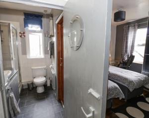 Elle comprend une petite salle de bains pourvue de toilettes et d'un lit. dans l'établissement Lovely Comfortable 3 Bed Home, Worcester, à Worcester
